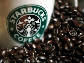 A mug bearing a Starbucks logo is pictured next to coffee beans during a news conference in Tokyo, in this file picture taken April 13, 2010. (REUTERS/Yuriko Nakao/Files)