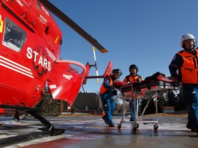 PHOTO COURTESY OF STARS. The Air Medical Crew push an empty stretcher away from a BK-117 helicopter at the QE2 hospital in Grande Prairie, AB. STARS/Mark Mennie