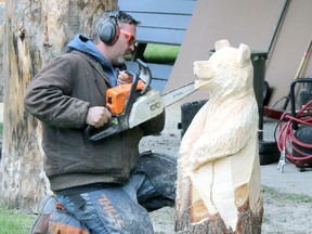 Local woodcarver, Mike Winia, creates a bear out of a wood log April 30, 2015.