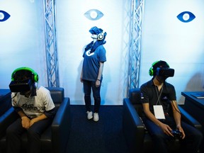 People try out Oculus VR's headset Oculus Rift Development Kit 2 at its booth in Tokyo Game Show 2014 in Makuhari, east of Tokyo Sept. 18, 2014. REUTERS/Yuya Shino
