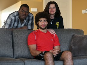 Smiths Falls teenager Neil Doef. who was paralyzed from the waist down playing hockey in December​, is flanked by parents Bruce and Bobbi-Jean at the family's new home. 
(Chris Hofley/Ottawa Sun)