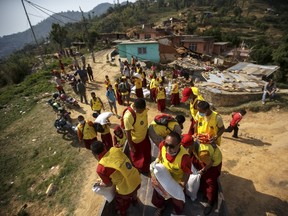 Nepali Buddhist monks from Benchen monastery unload relief supplies for earthquake victims as they arrive at Ramkot village on the outskirts of Kathmandu, Nepal, May 6, 2015. REUTERS/Athit Perawongmetha