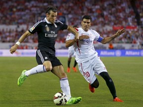 Real Madrid's Gareth Bale (left) is challenged by Sevilla's Jose Antonio Reyes during their Spanish first division match at Ramon Sanchez Pizjuan stadium in Seville, Spain, on May 2, 2015. (Marcelo del Pozo/Reuters)