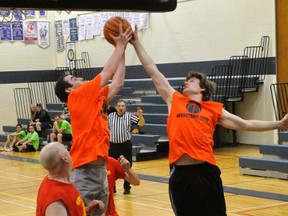 Pat Kemp (left) and Chris Wise, both of the ’11 OFSAA/Juicers team, both leap for the rebound during action from the championship final of the Mitchell Alumni basketball tournament Saturday, May 2. ANDY BADER/MITCHELL ADVOCATE