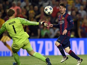 Barcelona forward Lionel Messi (right) slides the ball past Bayern Munich goalkeeper Manuel Neuer during their UEFA Champions League semifinal at the Camp Nou stadium in Barcelona May 6, 2015. (AFP PHOTO/LLUIS GENE)
