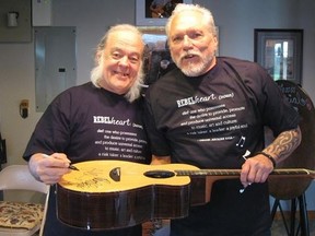 David Lindley, left, and Jorma Kaukonen autograph the Baden guitar that will be auctioned at Thursday?s concert, with proceeds going to the El Sistema Aeolian music program for youth. (David Southen/Special to Postmedia Network)