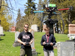 Wesley Gurr, left, and Jon Aarssen of Kingston Aerials control a drone at the Cataraqui Cemetery, which took aerial photos of the cemetery for mapping purposes on Wednesday. (Ian MacAlpine/The Whig-Standard)