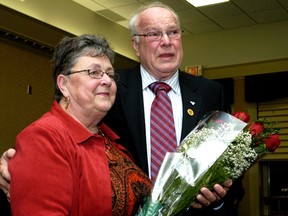 A tearful Bob Huskinson gives a bouquet to his wife, Janice, at his last city council meeting in this November 2006 file photo. (Ronald Zajac/Postmedia Network)