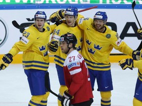 Sweden's Oscar Klefbom (top 2nd L) celebrates with his teammates Oliver Ekman-Larsson (L), Jacob Josefson (2nd R) and Joel Lundqvist after scoring a goal past Austria's Thomas Hundertpfund during their Ice Hockey World Championship game at the O2 arena in Prague, Czech Republic May 3, 2015.  REUTERS/David W Cerny
