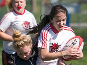Bayside's Amy Frotten tries to break a Brockville St. Mary's tackle during junior girls Spring Fun Run rugby tournament action Wednesday at MAS Park. (Tim Miller/The Intelligencer)