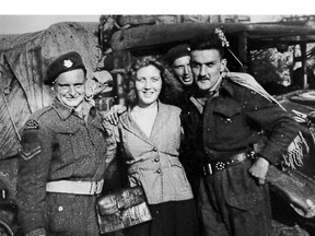 Canadian Army light infantryman John E. Cartwright, left, and fellow soldiers are greeted by Dutch citizens as they enter Rotterdam, Holland.