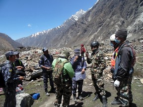 Soldiers take part in a operation to recover bodies after a massive avalanche triggered by last week's earthquake overwhelmed Langtang village, Nepal, in this May 2, 2015 police handout photo. About 100 bodies were recovered on Saturday and Sunday at Langtang village, 60 km (37 miles) north of Kathmandu, which is on a trekking route popular with Westerners. The entire village, which includes 55 guesthouses for trekkers, was wiped out by the avalanche and rescuers are digging in the snow for signs of about 120 others believed buried. REUTERS/Handout via Reuters
