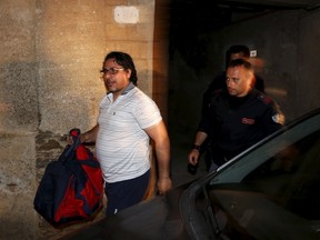 A man identified as Pino Fazio is escorted by Italian policemen after being detained during Operation Columbus in Pianopoli village, near Catanzaro, Italy May 7, 2015. Italian and U.S. agents broke up a major cocaine trafficking network between Central America, the United States and Europe on Thursday, detaining 13 Italians suspected of links to organised crime, police said. (REUTERS/Alessandro Bianchi)