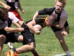 Senior boys rugby action between the Trenton High School Tigers (black) and Oakville Trafalgar High School's Red Devils during the annual 'McDougall Insurance and Financial Chargers Classic' at MAS Park in Belleville, Ont. Thursday, May 7, 2015. -  Jerome Lessard/Belleville Intelligencer/Postmedia Network