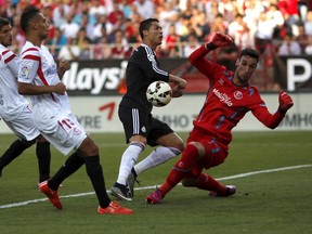 Sevilla's goalkeeper Sergio Rico (right) stops a shot from Real Madrid's Cristiano Ronaldo (second right) during their Spanish first division match at Ramon Sanchez Pizjuan stadium in Seville, Spain, on May 2, 2015. (Jon Nazca/Reuters)