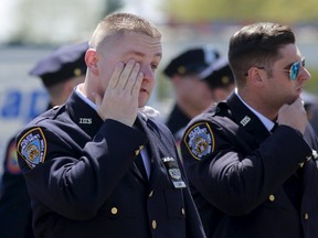 NYPD police officers leave the wake of officer Brian Moore at the Fredrick J. Chapey and Sons Funeral Home in Bethpage, New York, May 7, 2015. The New York City plainclothes police officer who was shot in the head died on Monday, the fifth officer gunned down in as many months amid anti-law enforcement sentiment not seen since the turbulent 1960s, Police Commissioner Bill Bratton said. REUTERS/Shannon Stapleton