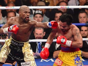 Floyd Mayweather Jr. (left)  connects against Manny Pacquiao during their welterweight unification bout on May 2, 2015 at the MGM Grand Garden Arena in Las Vegas. (AFP PHOTO/FREDERIC J. BROWN)