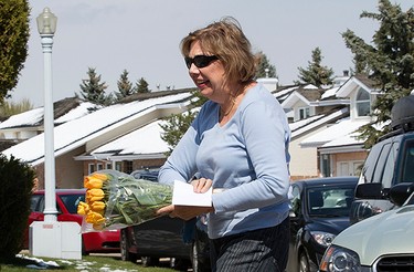 A woman (who did not want to give her name) drops off flowers and welcome card at the west Edmonton home where Omar Khadr will be staying with his lawyer Dennis Edney, in Edmonton, Alta. on Thursday May 7, 2015. David Bloom/Edmonton Sun/Postmedia Network