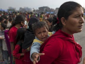 Victims of the April 25 earthquake line up during a food and water distribution at a camp for displaced people, in Kathmandu, Nepal, May 7, 2015. (REUTERS/Athit Perawongmetha)