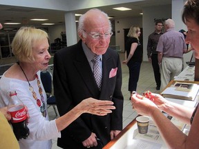 Baseball great Jim Fanning looks over St. Thomas native Jack Graney's World Series and Canadian Baseball Hall of Fame rings with Perry Mudd Smith, Graney's granddaughter, at Graney's 2014 induction to the St. Thomas Wall of Fame.