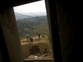 Earthquake victims work to rebuild a house after the April 25 earthquake at a village on the outskirts of Lalitpur May 8, 2015. REUTERS/Navesh Chitrakar
