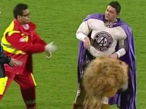Soccer mascot "Super Leo" is helped by security as he stumbles in a drunken state. (Sky Sport Austria/screen grab)