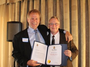 Financial planner Brian Callery, left, is congratulated by Oshawa Mayor John Henry, for The Calllery Group's 40 years of business in Durham Region.
