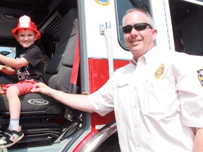 Four-year-old Owen Smith of Sarnia gets behind the wheel of a fire truck with the help of Point Edward deputy fire chief Rick MacGregor on Friday, May 8, 2015 in Sarnia, Ont. (Terry Bridge/Sarnia Observer/Postmedia Network)