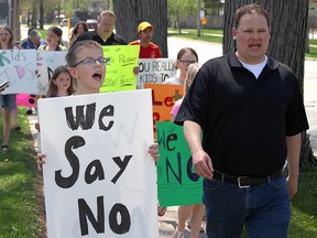 Hunter Workman, 12, walks alongside Jon McEachran at a rally outside the local public school board's Sarnia office Friday, protesting changes coming in September to Ontario's sexual-education curriculum. Organizers estimated about 60 people took part in the demonstration. (Tyler Kula, The Observer)
