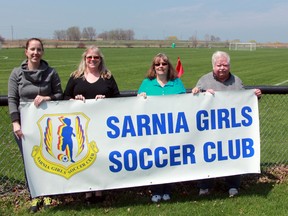 Sarnia Girls Soccer Club board member Candice de Bock, office administrator and sponsorship co-ordinator Donna Arcuri, president Susan Carnegie and operations manager Gordon Young hold a club banner on Wednesday May 6, 2015 in Sarnia, Ont. (Terry Bridge, The Observer)