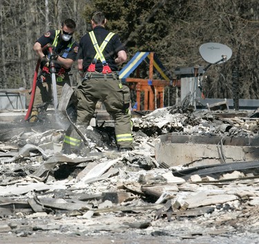 Firefighters from St. Albert, AB work to put out more hotspots as they continue to flare up in Slave Lake, AB after a destructive forest fire ravaged the town, leaving it a disaster zone of rubble and ash on May 17, 2011.
A mandatory evacuation was in effect for the town of 7,000, which is located approximately 250 kms northwest of Edmonton, AB.  The town hall, library, radio station, and hundreds of homes have burnt down.   (Edmonton Sun File)