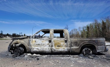 A burned out truck sits in a destroyed neighborhood in Slave Lake, Alberta May 17, 2011. Parts of the town were devastated by wild fires that rolled through the area late Monday night and early Tuesday morning. About 100 wildfires are burning in Alberta, spurred by warm temperatures and gusting winds, with 23 considered out of control in a fire season unlike any seen before. REUTERS/Todd Korol