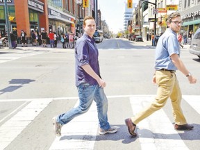 Aaron McMillian, left, and Ryan Craven organizers of the downtown music festival walk across Dundas at Richmond. (MORRIS LAMONT, The London Free Press)