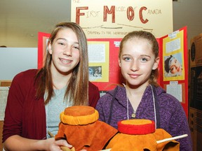 Grade 7 students Jordan Voogt, left and Lola Young made water drums as part of their heritage project about the First Music in Canada for the Regional Kingston Heritage Fair at Duncan McArthur Hall on Thursday. (Julia McKay/The Whig-Standard)