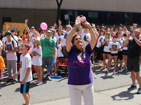 Denise Bebenek, the founder of Meaghan's Walk, blows kisses and waves to children waving from the window of SickKids Hospital Saturday. The annual event to benefit pediatric brain tumour research has raised over $4-million since is started 14 years ago. (SHAWN JEFFORDS/TORONTO SUN)