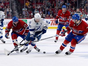 Tampa Bay Lightning forward Steven Stamkos (91) is checked by Montreal Canadiens forward Torrey Mitchell (17) and teammate Alexei Emelin (74) during the second period in game five of the second round of the 2015 Stanley Cup Playoffs at the Bell Centre. Eric Bolte-USA TODAY Sports