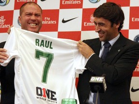 Dec 9, 2014; New York, NY, USA;  New York Cosmos head coach Giovanni Savarese (left) and  New York Cosmos player  Raul Gonzalez hold up a jersey during a press conference at Four Seasons Hotel.  Mandatory Credit: Noah K. Murray-USA TODAY Sports