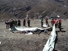 Recovered bodies are lined up after a massive avalanche triggered by last week's earthquake overwhelmed Langtang village, Nepal, in this May 2, 2015 police handout photo. Rescue workers are struggling to recover the bodies of nearly 300 people, including about 110 foreigners, believed to be buried under up to six metres (20 feet) of ice, snow and rock from the landslide that destroyed Langtang village. Picture taken May 2, 2015. REUTERS/Handout via Reuters