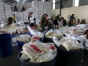 Members of the Armed Forces of the Philippines help out volunteers repacking food rations for victims of Typhoon Noul at the Department of Social Welfare Development (DSWD) headquarters in Pasay city, south of Manila May 9, 2015. The Philippines on Saturday evacuated thousands of people in the northeastern part of its main island of Luzon on Saturday, less than 24 hours before a powerful typhoon was expected to make landfall. Typhoon Noul, a category 4 storm with winds of 160 kph (99 mph) and gusts of up to 195 kph, was about 210 kms (130 miles) north northeast of Catanduanes island in the central Philippines.    REUTERS/Romeo Ranoco