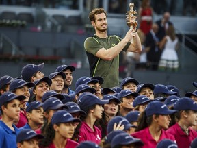 Britain's Andy Murray raises up his trophy as he poses with boyballs after winning the final match over Spain's Rafael Nadal at the Madrid Open tennis tournament in Madrid, Spain, May 10, 2015. (REUTERS/Sergio Perez)