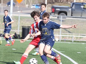 Eric Tessier of Macdonald Cartier and Eric Sampson of College Notre Dame fight for the ball during senior boys high school soccer action  from James Jerome Field in Sudbury, Ont. on Thursday May 7, 2015.