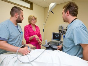 Dr. Pat Morley-Forster, middle, talks with Dr. Mike Pariser, left, and Dr. Amjad Bader as they perform an ultrasound on a patient's neck at St. Joseph's Pain Management Clinic. (CRAIG GLOVER, The London Free Press)