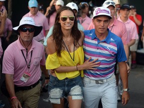 Rickie Fowler and girlfriend Alexis Randock walk to the trophy presentation after Fowler won The Players Championship at TPC Sawgrass on May 10, 2015. (Jake Roth/USA TODAY Sports)