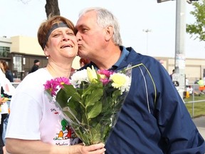 Sandra Longarini gets flowers from her husband Denis, both from Sudbury, ON, after she finished her first ever 5 K run during the Sport Chek Mother’s Day Run, Walk and Ride. on Sunday May 10, 2015 in Calgary, Alta. The annual walk, run and bike ride event benefits neo-natal intensive care units in city hospitals, committing at least $200,000 to improve care for Calgary’s newest, and tiniest, residents. Jim Wells/Calgary Sun/Postmedia Network