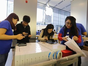 Customers get their pre-ordered iPhone 6 at an Apple store in Beijing, Oct. 17, 2014. REUTERS/JASON LEE