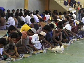 Migrants believed to be Rohingya eat inside a shelter after being rescued from boats, in Lhoksukon, Indonesia's Aceh Province May 11, 2015.  Nearly 600 migrants thought to be Rohingya refugees and Bangladeshis were rescued from at least two wooden boats stranded off the coast of Indonesia's Aceh province on Sunday, authorities said. 
REUTERS/Roni Bintang