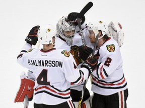 (L-R) Niklas Hjalmarsson #4, Corey Crawford #50 and Duncan Keith #2 of the Chicago Blackhawks celebrate a win against the Minnesota Wild in Game Three of the Western Conference Semifinals during the 2015 NHL Stanley Cup Playoffs on May 5, 2015 at Xcel Energy Center in St Paul, Minnesota. (Hannah Foslien/Getty Images/AFP)