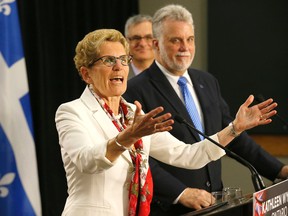 Ontario Premier Kathleen Wynne with Quebec Premier Philippe Couillard discussing new agreements between the provinces at Queen's Park in Toronto on Monday May 11, 2015. (Michael Peake/Toronto Sun)