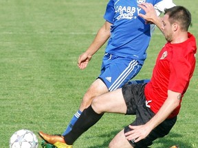 Wallaceburg Sting player Jake Zelina fights for the ball against a London Portuguese player on May 9 at Wallaceburg's Kinsmen Park. London won the regular season opener 2-1.