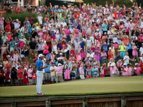 Fans cheer Rickie Fowler as he pumps his fist on the island green at the 17th hole at TPC Sawgrass after winning the Players Championship in a playoff Sunday. (Getty Images/AFP)